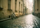 Mokry bruk uliczki w centrum Krakowa wczesnym rankiem, rower pod ścianą kamienicy